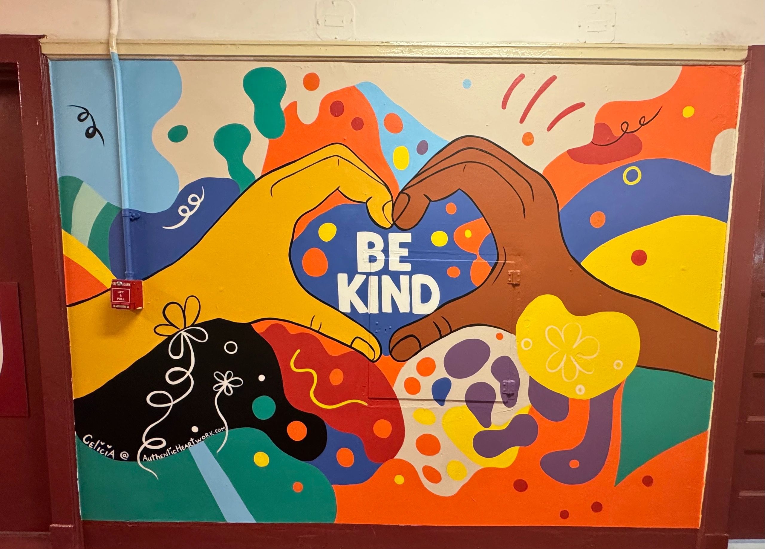 Be Kind mural with colorful hands — school environment